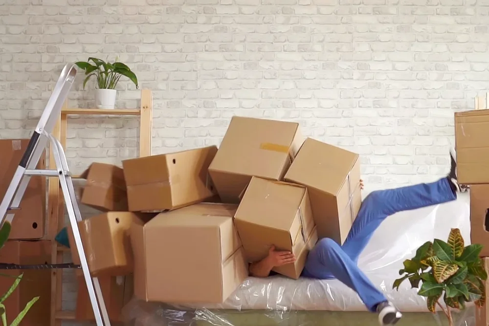 Umzugsfehler-Mann-mit-schweren Zügelkisten